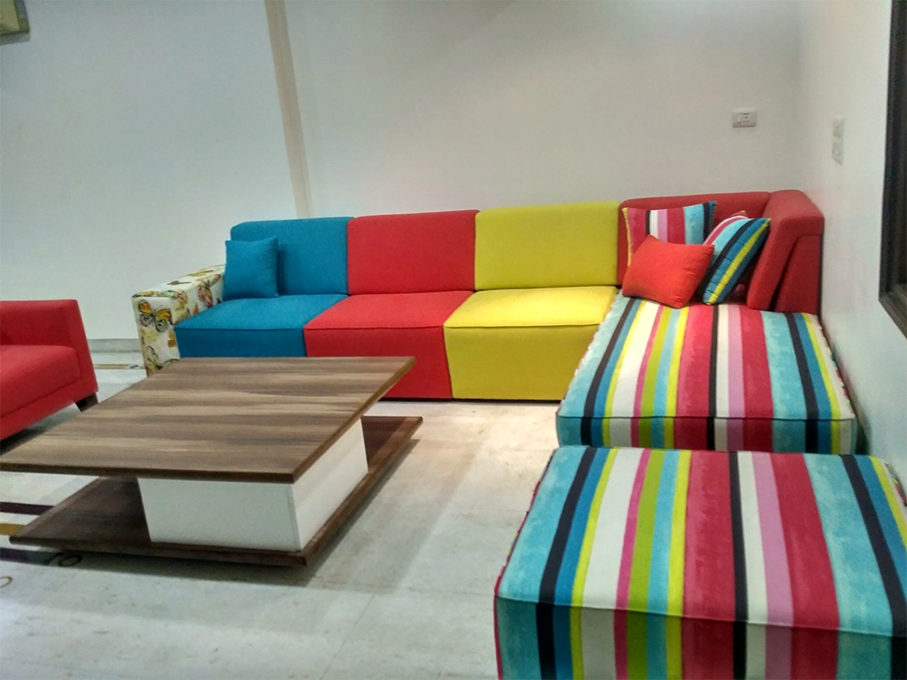 A multi color L shaped seven seater sofa set with center table for Living room area.