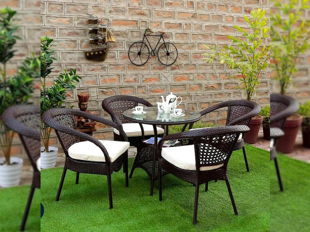 four pcs Brown color Patio design wicker chair with white color cushion and one pcs round center table with glass top for outdoor.