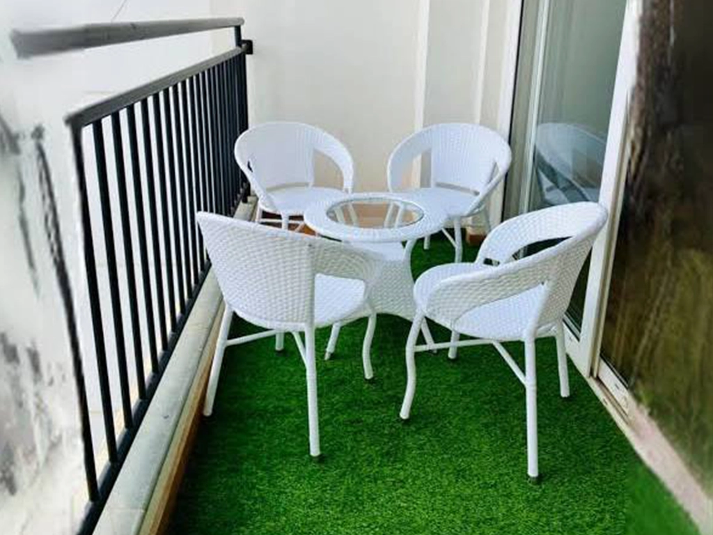 four pcs white color balcony wicker chair and one round table with glass top.