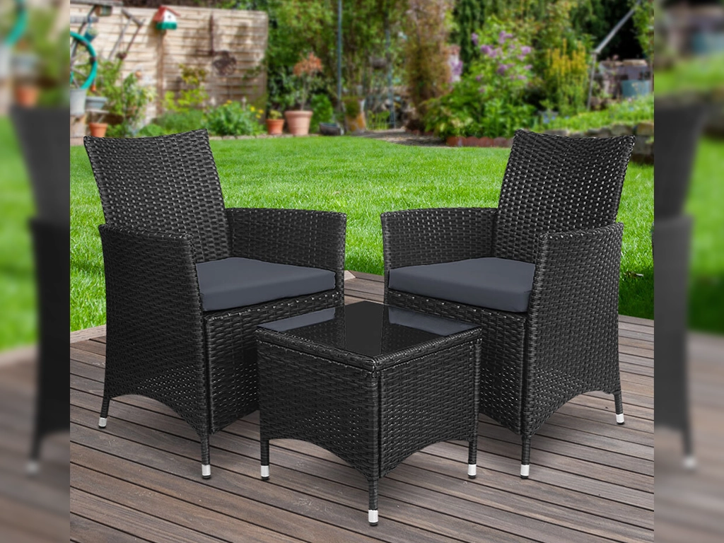 Black color wicker outdoor chair & table, chair with cushion and table with glass top.