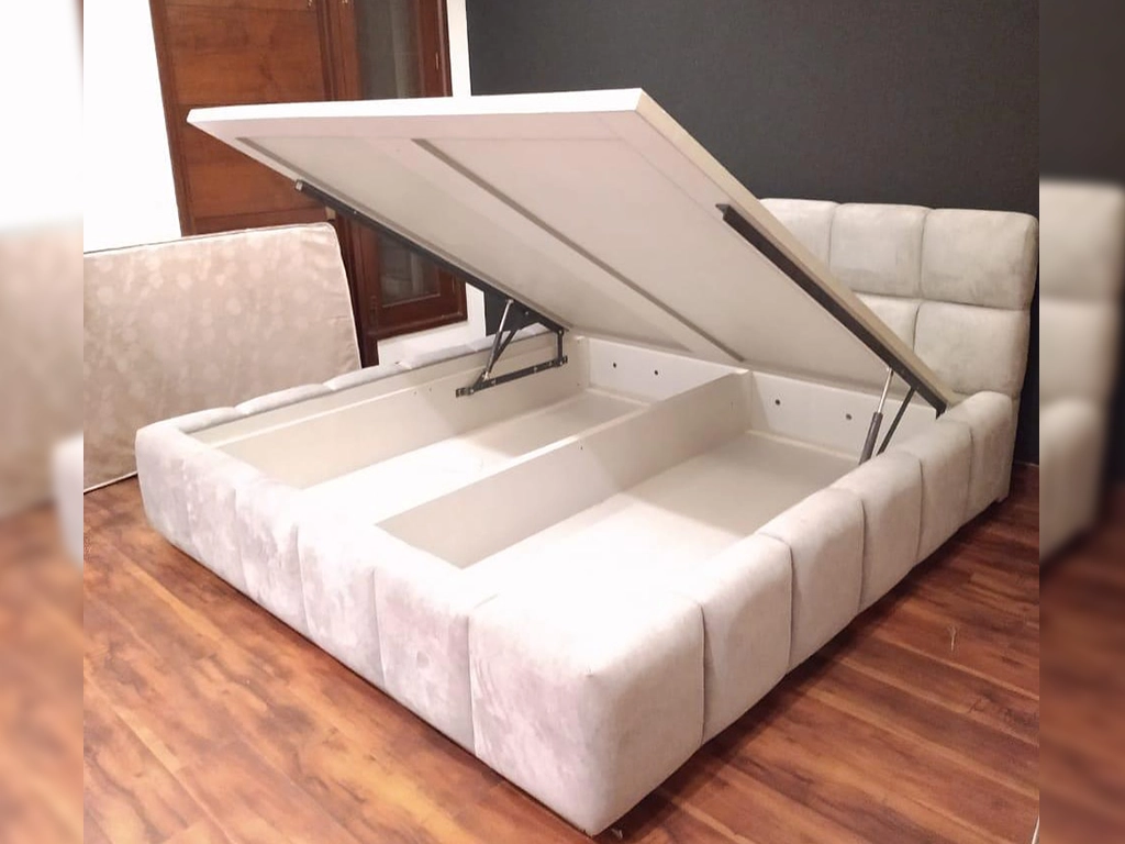 A white color cushioning all side square design work double bed for living area.