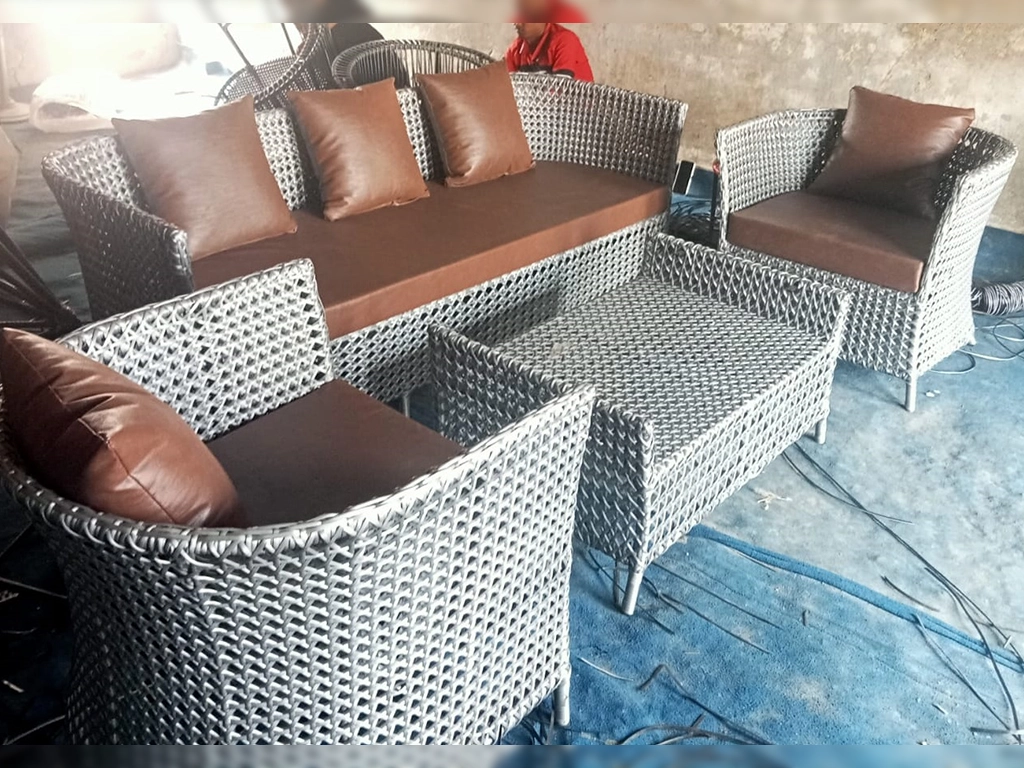 grey color wicker sofa five seater with tan color leatherette cushion & pillow and center table for garden area and outdoor area.