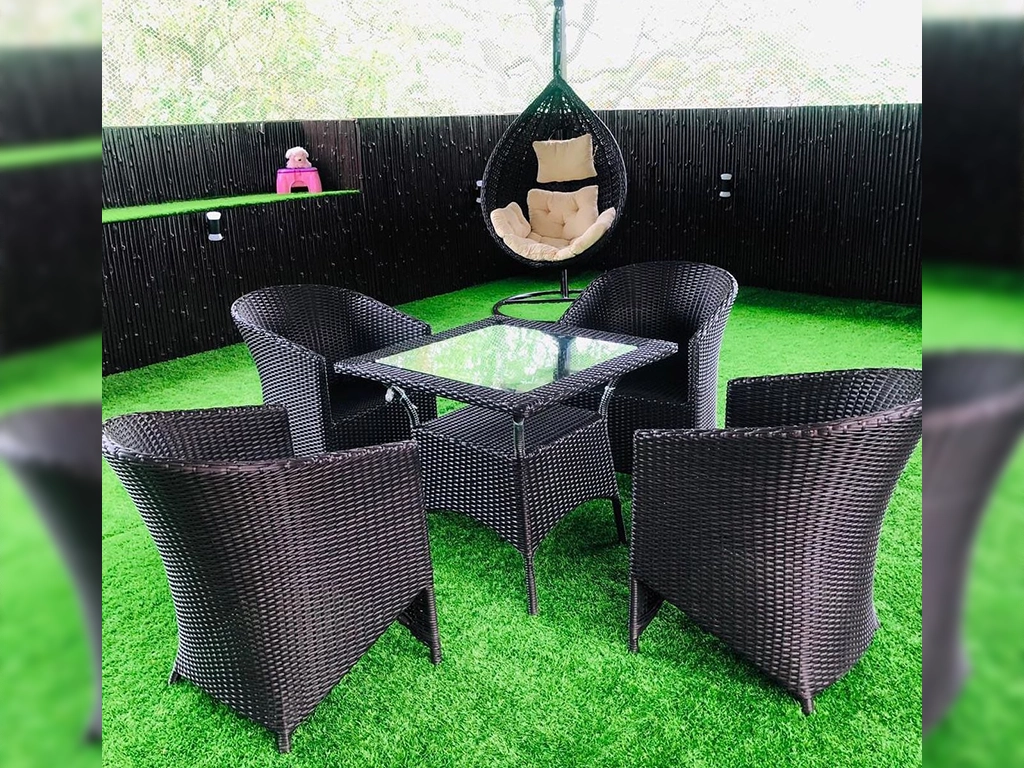 four pcs black color wicker chair and one pcs square center table with glass top in garden garden area.